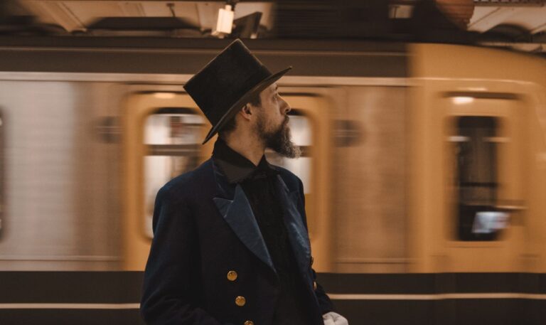 A man dressed in vintage clothing stands on a subway platform in Buenos Aires.
