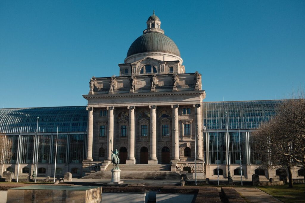Grand view of the Bavarian State Chancellery in Munich, framed by a clear blue sky.